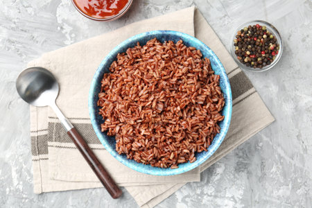 Delicious brown rice served on grey textured table, flat layの写真素材