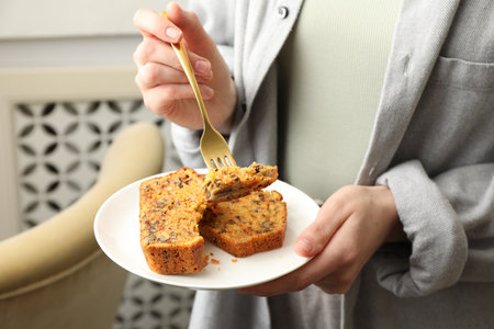Woman eating homemade carrot cake indoors, closeupの写真素材