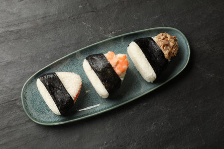 Tasty onigiri (Japanese rice balls) served on black table, top viewの写真素材