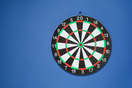 One dart board hanging on blue wall, space for textの写真素材
