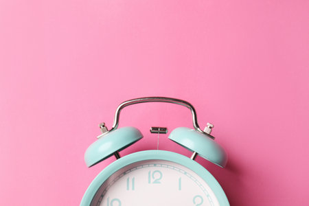Turquoise alarm clock on pink background, top view. Space for textの写真素材