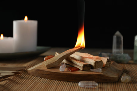 Burning palo santo stick, gemstones and candles on table, closeupの写真素材