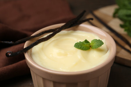Tasty vanilla pudding, mint and pods on table, closeupの写真素材