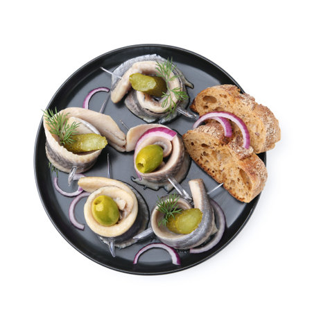 Herring rolls with olives, pickles, dill, onion and bread pieces isolated on white, top viewの写真素材