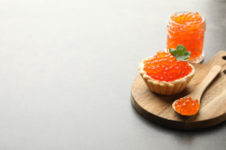 Tasty canape with red caviar, spoon and parsley on grey table, closeup. Space for textの写真素材