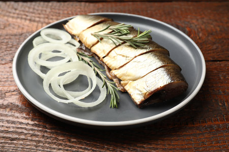 Smoked herring, onion and rosemary on wooden table, closeupの写真素材