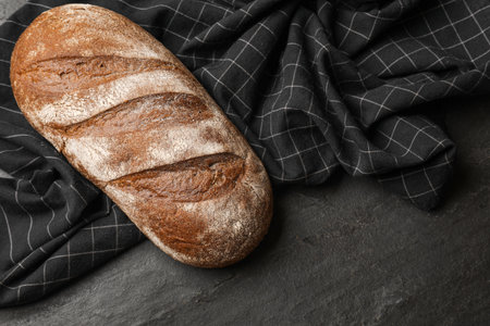 Fresh loaf of bread on black table, top viewの写真素材