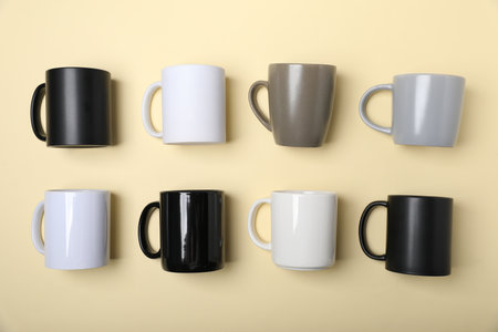 Many different cups on pale yellow background, flat layの写真素材