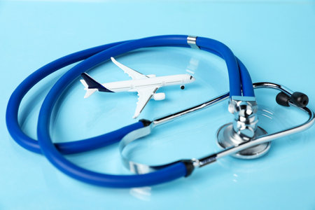 Stethoscope and airplane model on light blue background, closeupの写真素材