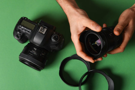 Photographer with professional camera and equipment on green background, top viewの写真素材