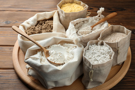 Different types of flour in bags on wooden table, closeupの写真素材