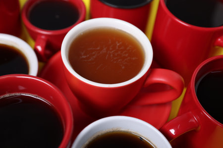 Different cups with aromatic coffee drinks on yellow background, closeupの写真素材