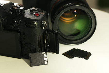 SD memory cards and photo cameras on white table, closeup