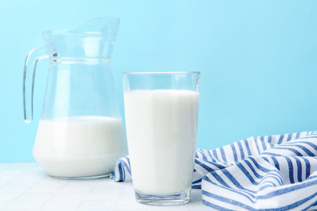 Fresh milk on white table against light blue backgroundの写真素材