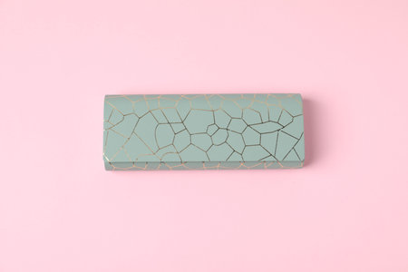 Glasses case on light pink background, top view