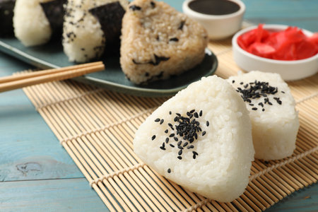 Rice balls (onigiri) served on light blue wooden table, closeup. Traditional Japanese dishの写真素材