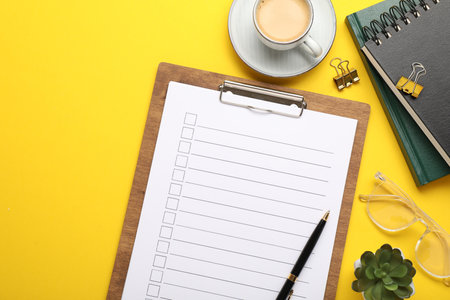 Flat lay composition with checklist on yellow backgroundの写真素材