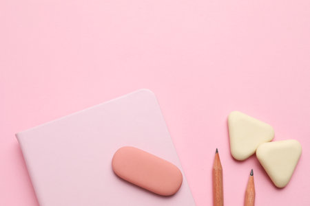 Erasers, notebooks and pencils on pink background, flat layの写真素材