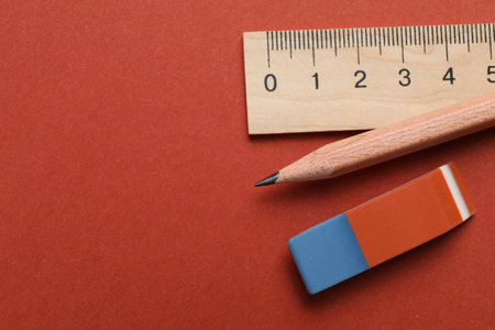 Eraser, ruler and pencil on brown background, flat lay. Space for textの写真素材