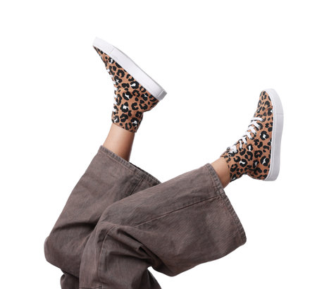 Woman wearing stylish sneakers on white background, closeup
