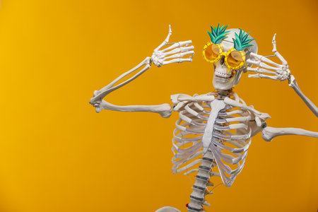 Artificial human skeleton model on orange background, space for textの写真素材