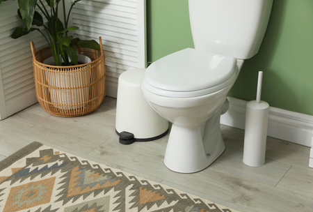 Ceramic toilet bowl, brush and necessities in restroom