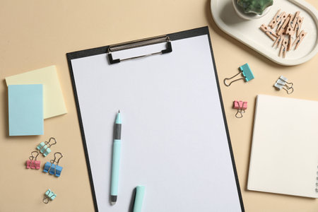Flat lay composition with clipboard and blank paper on beige background. Space for textの写真素材