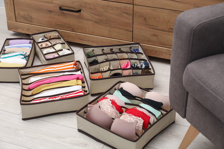 Organizers with folded clothes on floor indoors