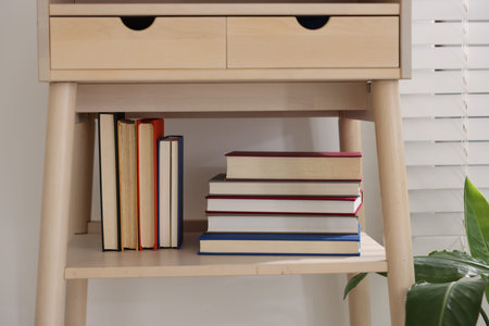 Different books on shelf of nightstand indoorsの写真素材