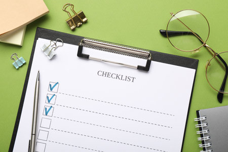 Flat lay composition with checklist on green backgroundの写真素材