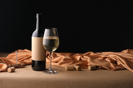 Bottle of wine, wineglass and cloth on brown table, space for textの写真素材