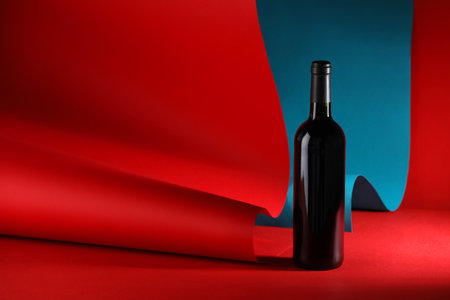One bottle of tasty wine on color background. Space for textの写真素材