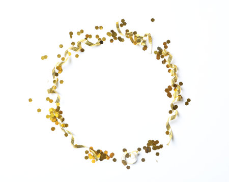 Frame of shiny golden serpentine streamers and confetti on white background, top viewの写真素材