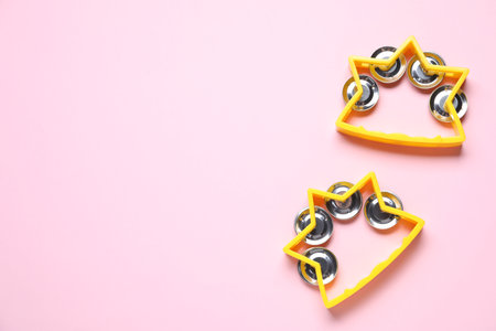 Bright toy tambourines on pink background, flat lay. Space for textの写真素材