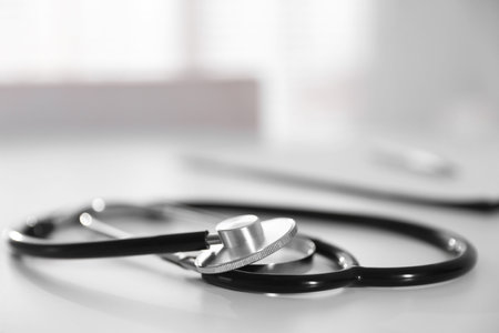 Stethoscope and paperwork on white desk in hospital, selective focus. Space for textの写真素材