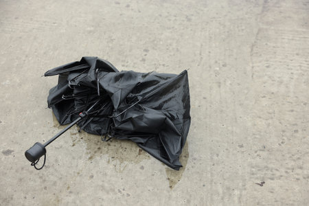 Broken black umbrella on wet outdoors