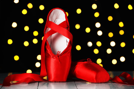 Pair of beautiful pointe shoes on floor against blurred lights. Bokeh effectの写真素材