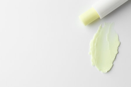 Stick of lip balm and sample on white background, top view. Space for textの写真素材