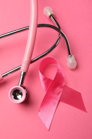 Breast cancer awareness. Pink ribbon and stethoscope on color background, flat layの写真素材