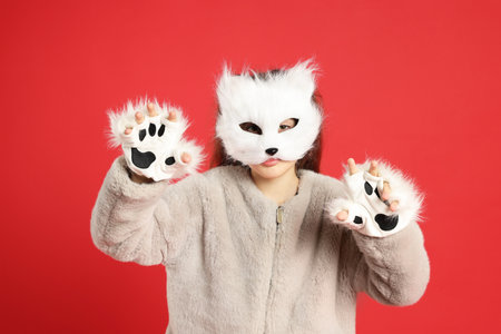 Quadrobics. Girl wearing cat mask and gloves on red backgroundの写真素材