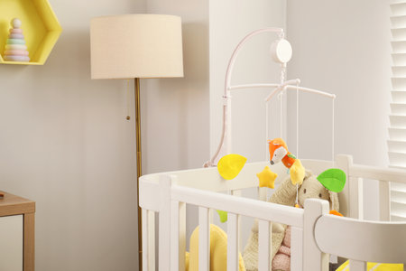 Crib with baby mobile and lamp in child's roomの写真素材