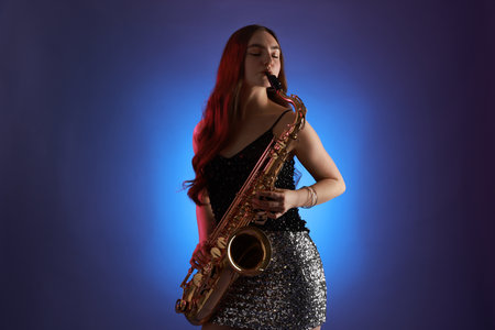 Professional musician playing saxophone on color backgroundの写真素材