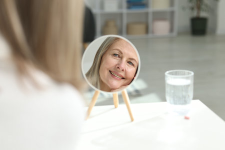Smiling woman with healthy skin at table indoorsの写真素材