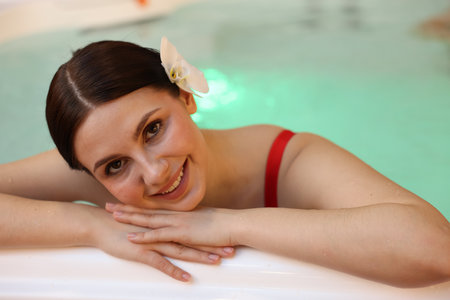 Beautiful woman relaxing in hot tub indoorsの写真素材