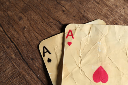 Old vintage playing cards on wooden table, flat lay. Space for text