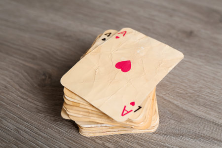 Many old vintage playing cards on wooden table, closeup