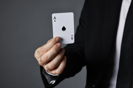 Illusionist with playing card on grey background, closeupの写真素材
