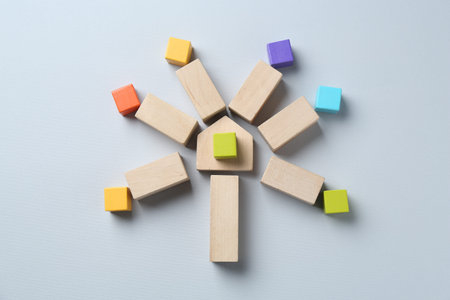 Family tree made with colorful cubes and wooden blocks on light grey background, top view