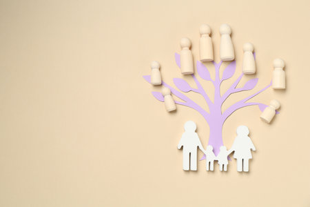 Family tree made with wooden pieces and people figure on beige background, top view. Space for textの写真素材