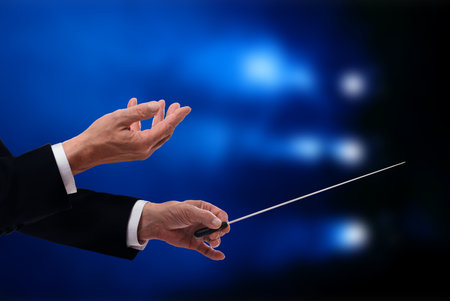 Conductor with baton in concert hall, closeupの写真素材